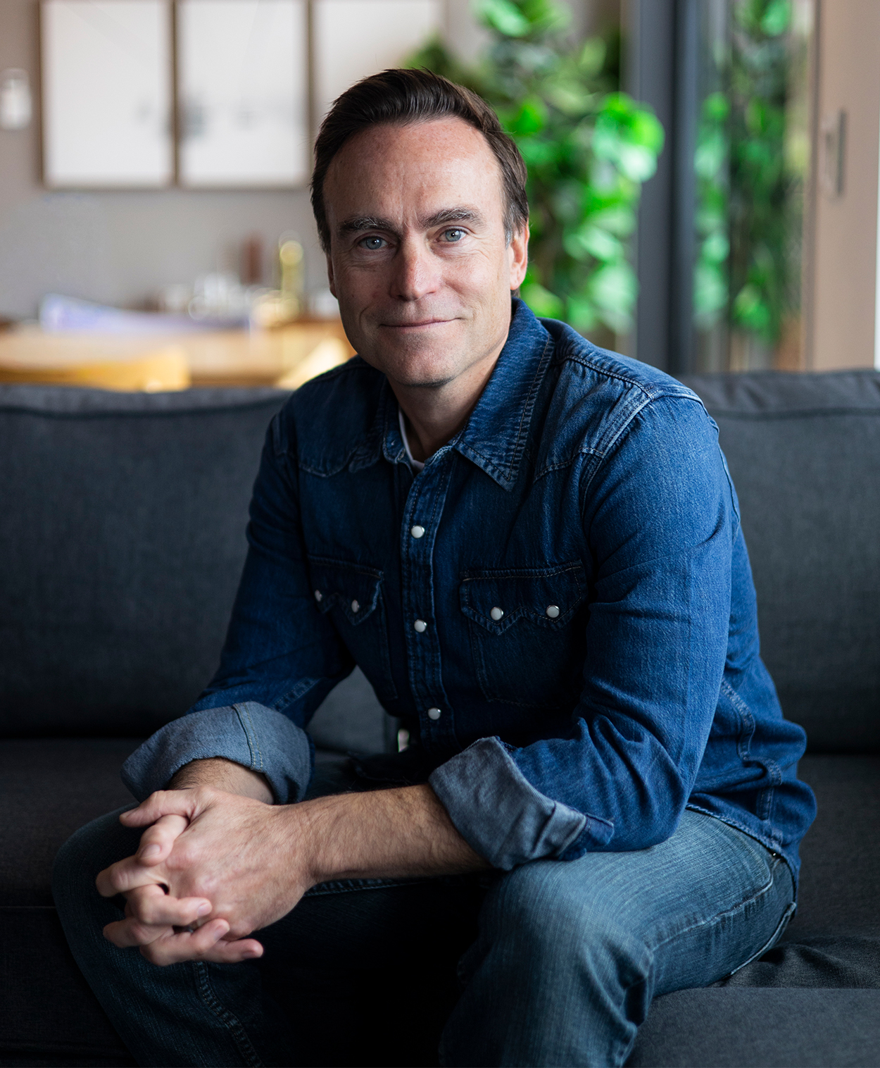 dr. duerler sitting on couch and smiling