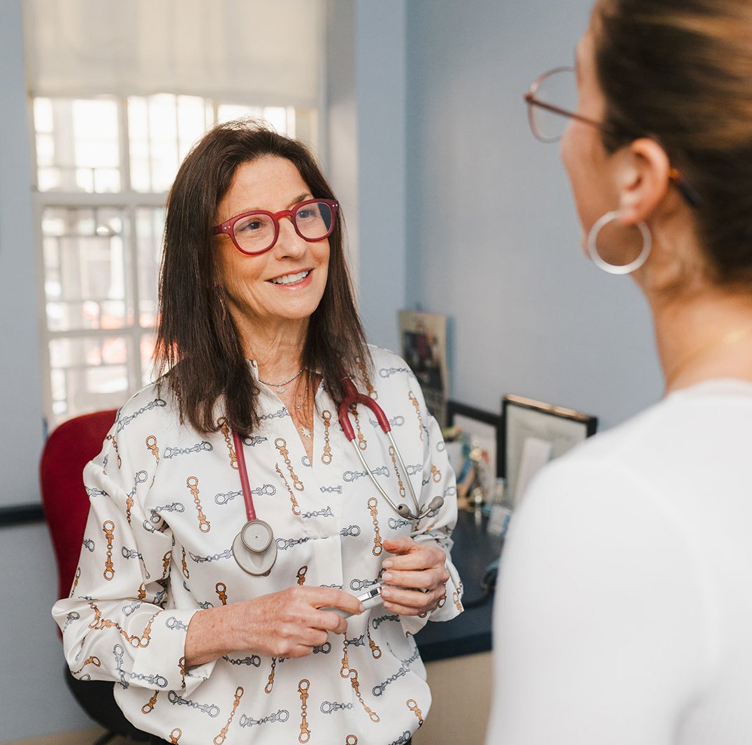 women physician smiling and talking with patient