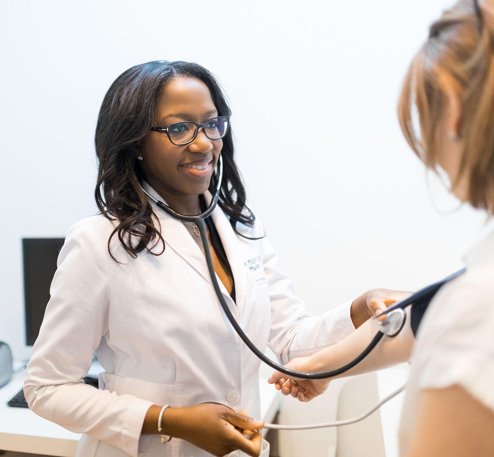 woman physician taking blood pressure on patient